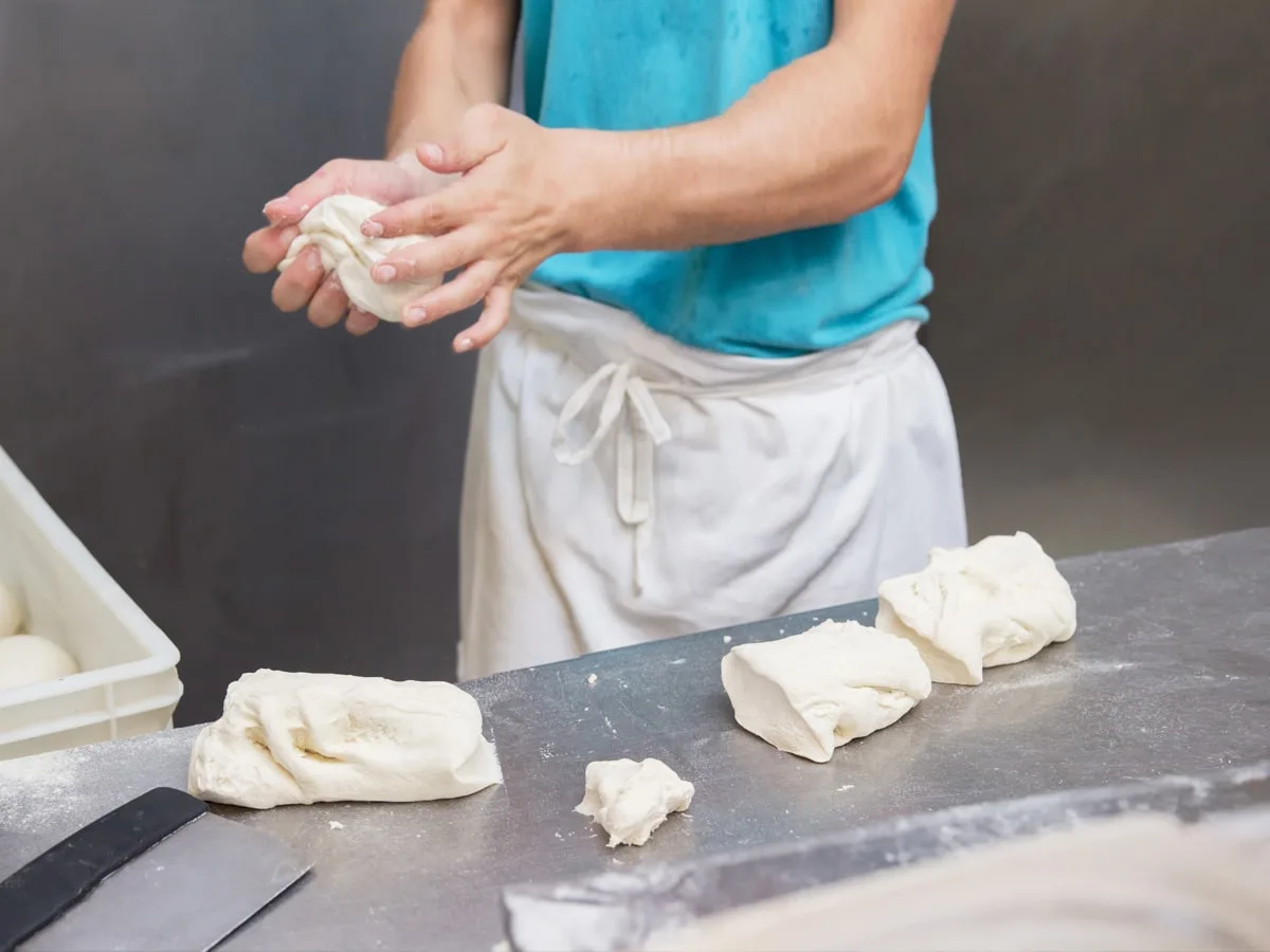Pizzabäcker bereitet Pizzateig zum gehen über Nacht vor.